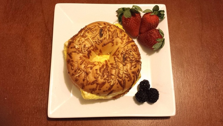 Cheese Bagel with an Omelette and a Side of Strawberries and Blackberries